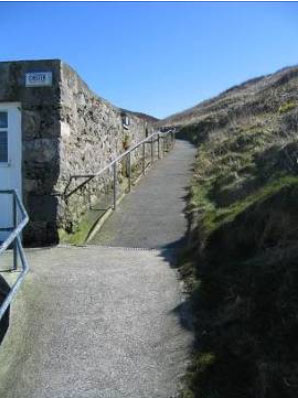 A sloping footway with handrail provision in one side only.
